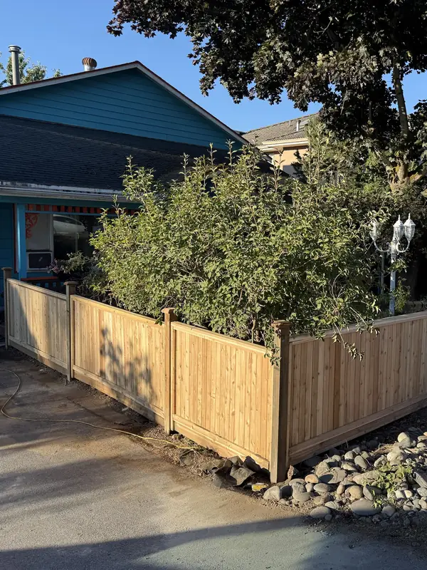 New cedar fence with post caps wrapping the front garden of a corner lot