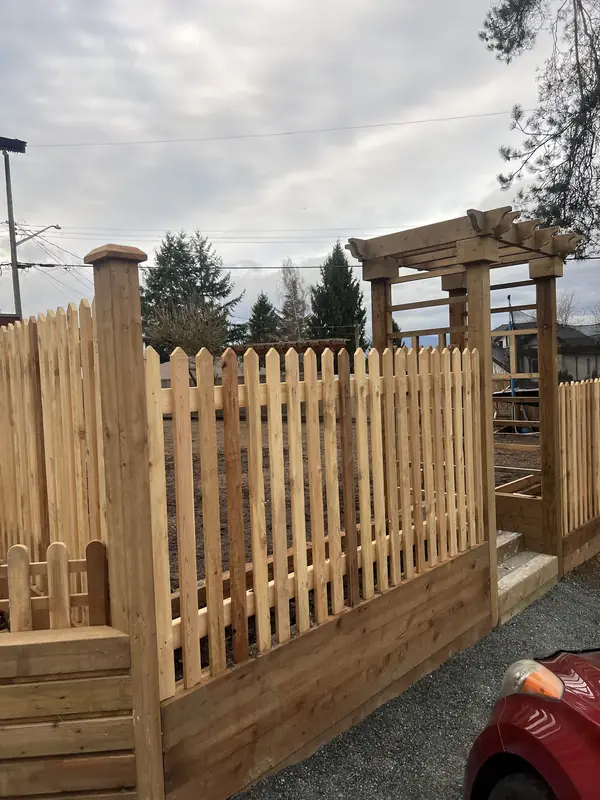 Cedar picket fence on a timber wall beside a cedar arbour over the entry steps
