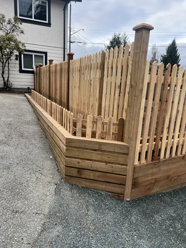 Cedar picket fence on a timber retaining wall, with a low picket edge along the planter