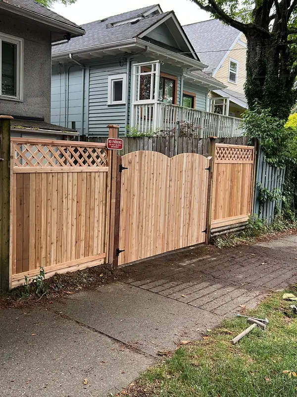 Double arched cedar driveway gate between lattice-top cedar panels