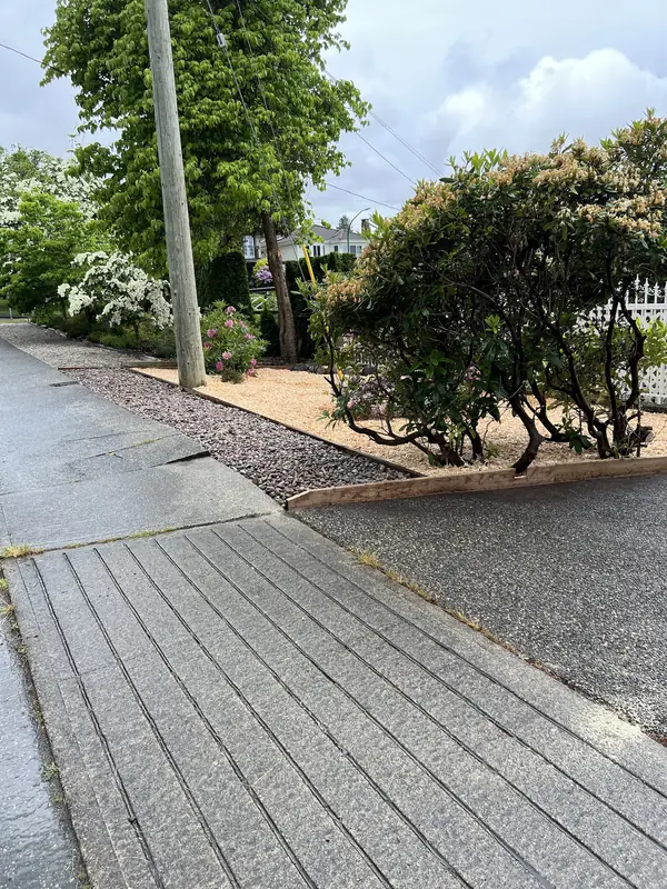 Front garden with fresh cedar mulch, timber edging and a river rock strip along the sidewalk