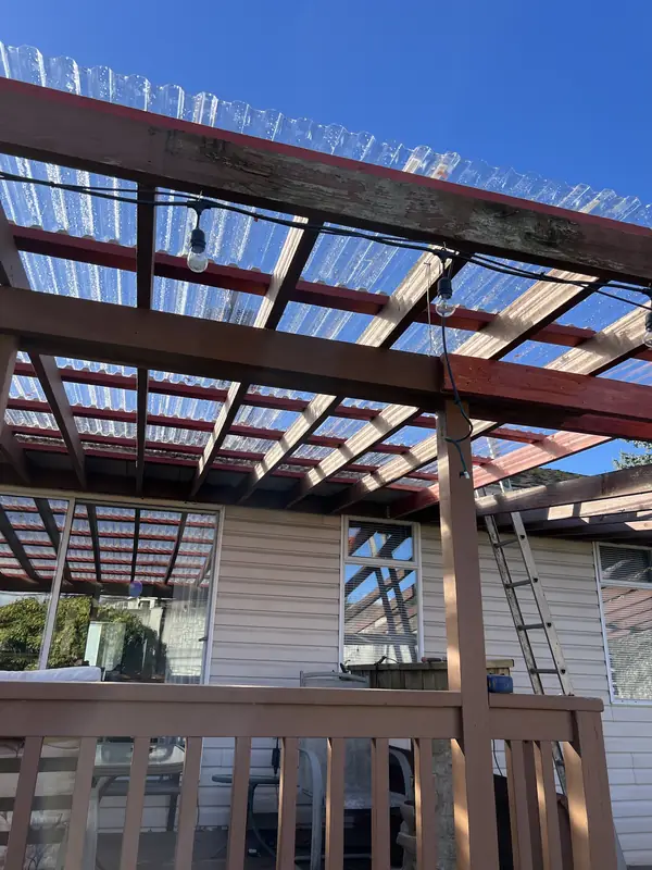 Pergola frame and new clear roof panels seen from below at an angle