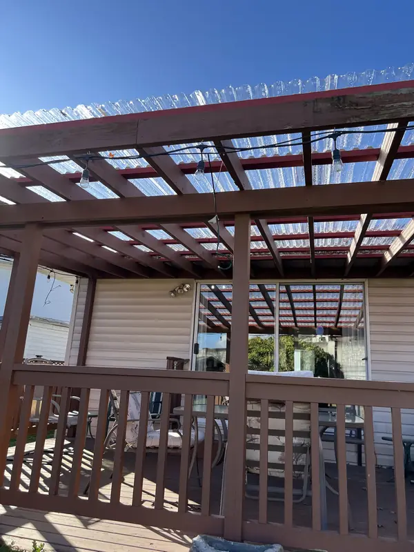 Pergola over a deck with new clear corrugated roof panels on red purlins