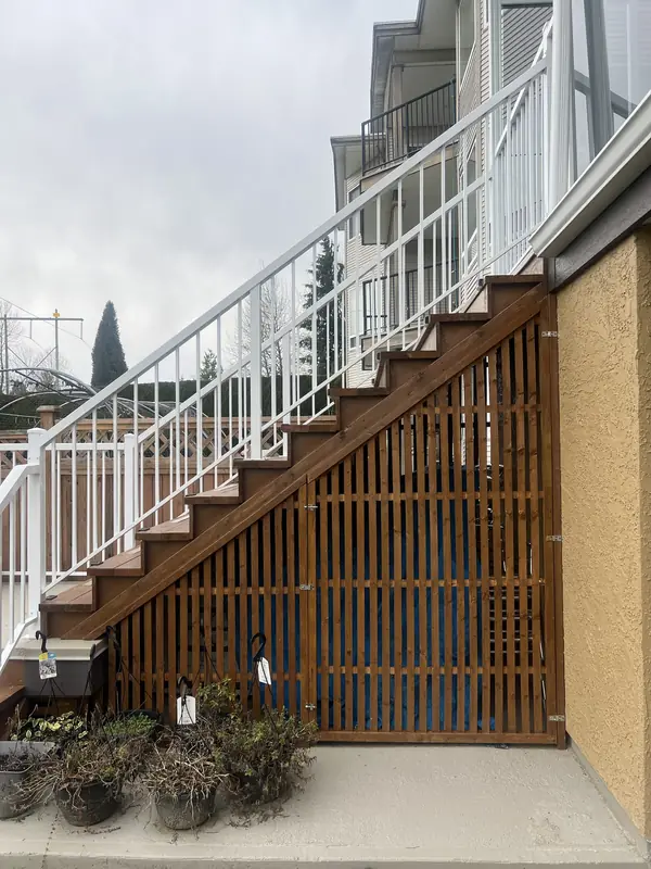 Cedar slat screen with two doors closing in the storage space under an outdoor stair